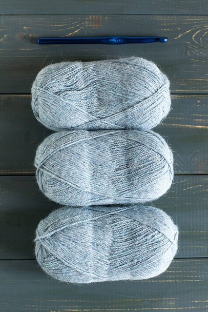 Yarn and crochet hook on a wooden table close-up - Фото, зображення