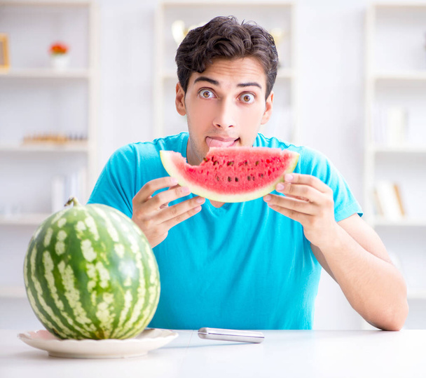Man die thuis watermeloen eet - Foto, afbeelding