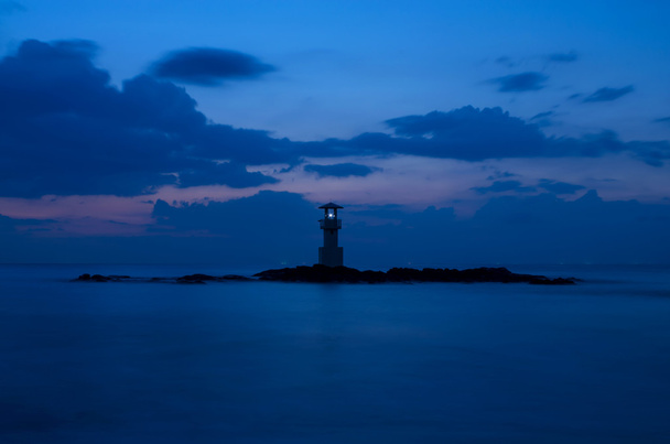 Meereslandschaft bei Sonnenuntergang mit Leuchtturm an der Küste - Foto, Bild