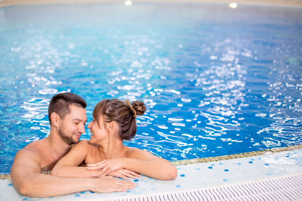 cheerful loving young people spending great time in the swimming pool. - Fotó, kép
