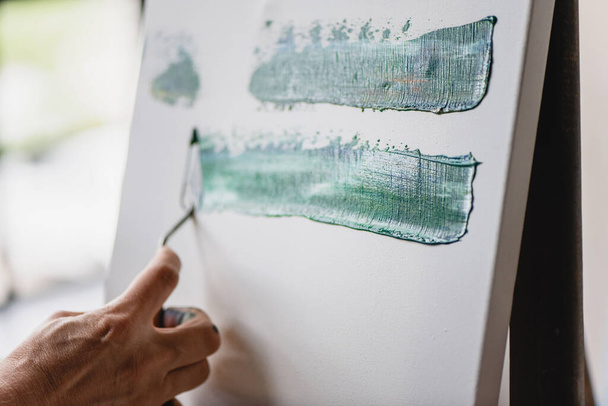 Artist hand painting on canvas with spatula. - Fotoğraf, Görsel