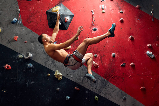 Panoramic man bouldering at an indoor climbing centre. - Foto, Bild