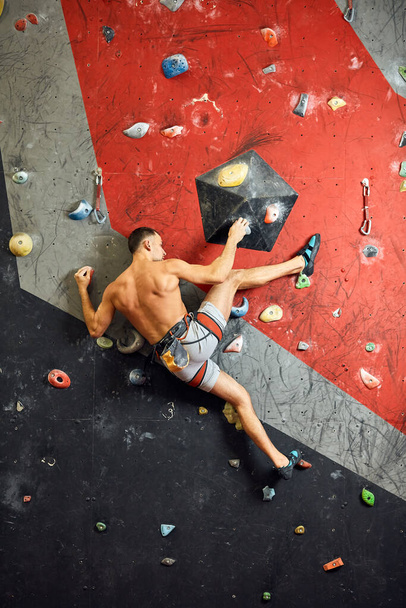 Male professional climber at indoor workout at bouldering centre. - Foto, immagini