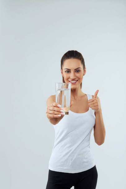Portrait of beautiful woman on isolated studio background, hold water glass. Drink water. Diet concept - Foto, Bild