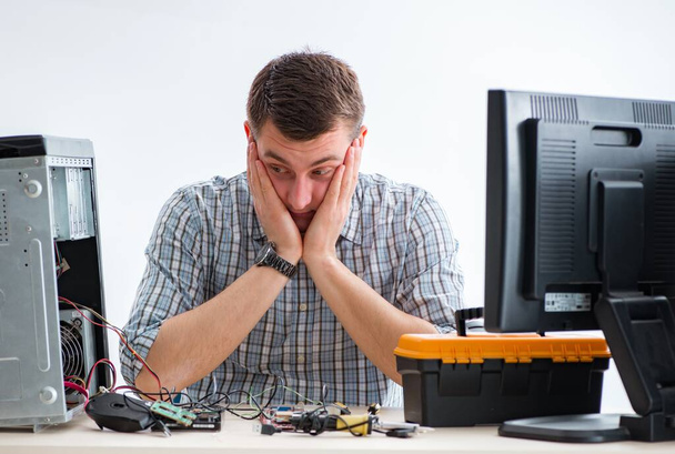 Jonge technicus repareert computer in werkplaats - Foto, afbeelding