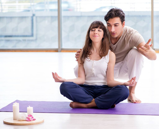 Entrenador personal ayudando durante sesión de yoga - Foto, imagen