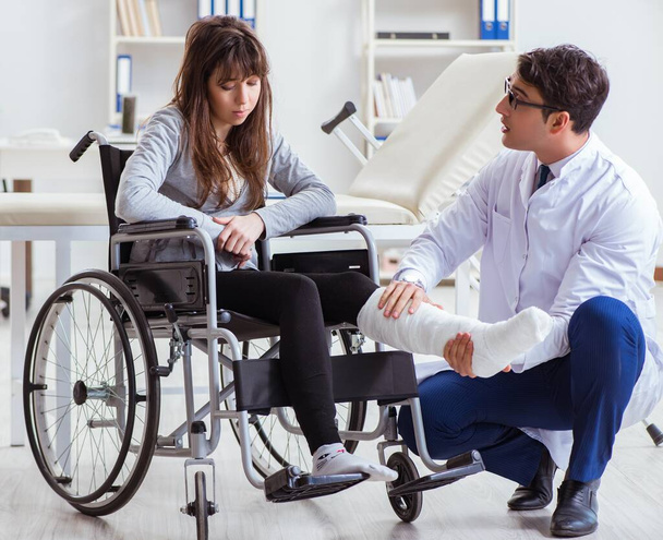 Medico maschio che esamina paziente femminile sulla sedia a rotelle - Foto, immagini
