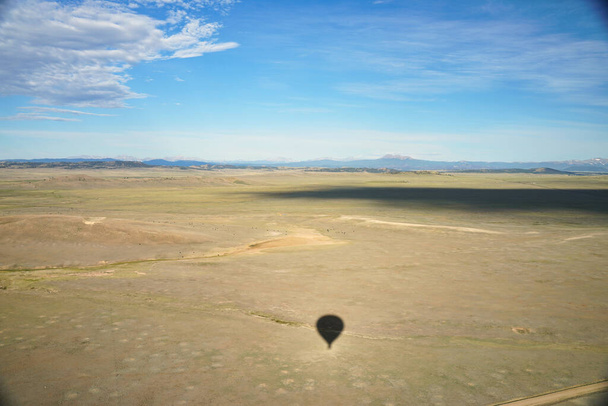 Paisaje colordo desde globo aerostático. Sombra de globo visible en los aviones. Las montañas se pueden ver en la distancia - Foto, Imagen