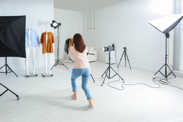 Professional photographer taking picture of ghost mannequins with modern clothes in photo studio - Fotografie, Obrázek