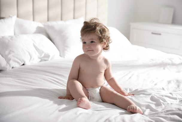 Cute little baby on bed at home - Foto, afbeelding