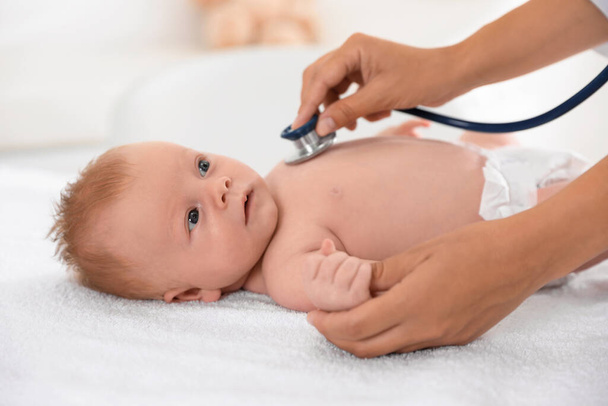 Doctor examining cute baby with stethoscope indoors, closeup. Health care - Valokuva, kuva