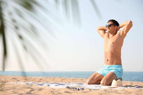 Happy man with slim body resting on beach. Space for text - Zdjęcie, obraz
