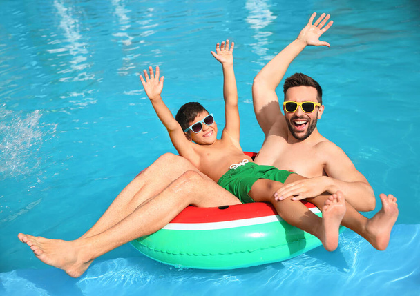Father and son having fun in swimming pool. Family vacation - Фото, зображення