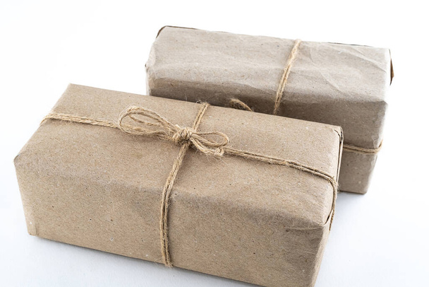 boîte cadeau couple en papier artisanal brun foncé et ruban de jute sur fond blanc - Photo, image
