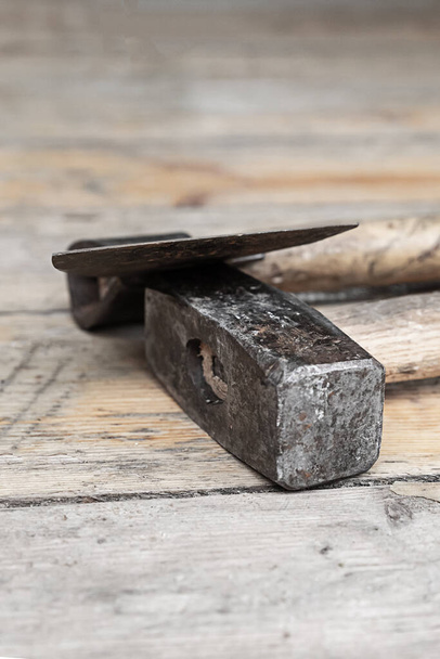 paire d'outils de travail constructeur hache et marteau lourd sur fond en bois - Photo, image