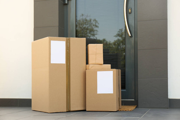 Cardboard boxes near door. Parcel delivery service - Foto, Imagem