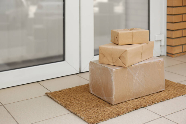Delivered parcels on door mat near entrance - Zdjęcie, obraz