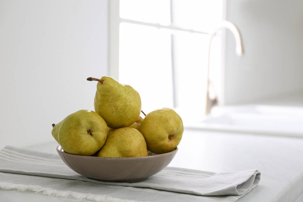 Fresh ripe pears on countertop in kitchen. Space for text - Foto, afbeelding