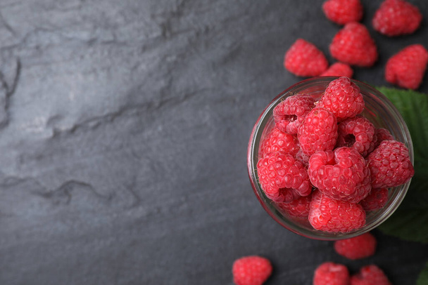 Delicious fresh ripe raspberries on black table, flat lay. Space for text - Foto, Bild