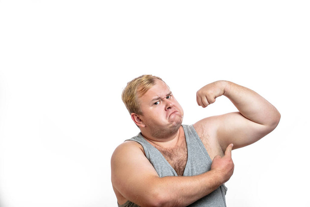 Funny overweight sports man flexing his muscle isolated on white background - 写真・画像
