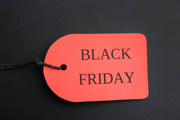 Red tag with words BLACK FRIDAY on dark background, top view - Foto, Imagen