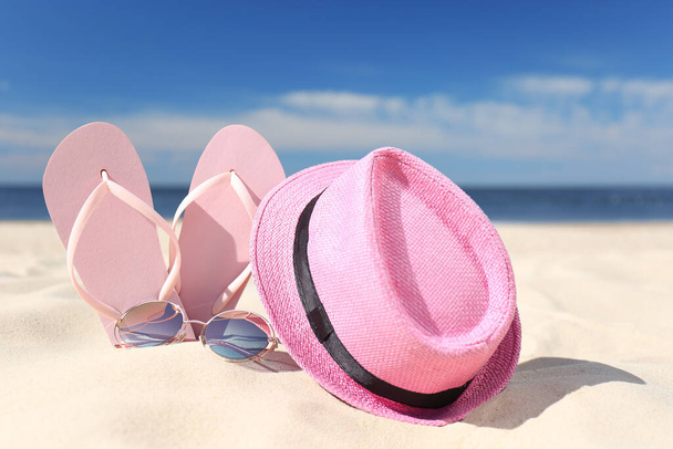 Stylish beach accessories for summer vacation on sand near sea - Фото, зображення