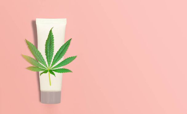 CBD Cannabis Hemp topical cream balm with cannabis leaf on pink backdrop - Photo, Image