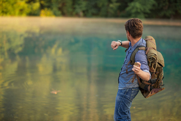 young traveler is throwing somethin into the river - Fotoğraf, Görsel