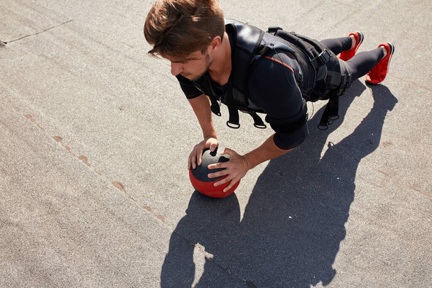 awesome sportsman is doing exercises with a ball - Photo, Image