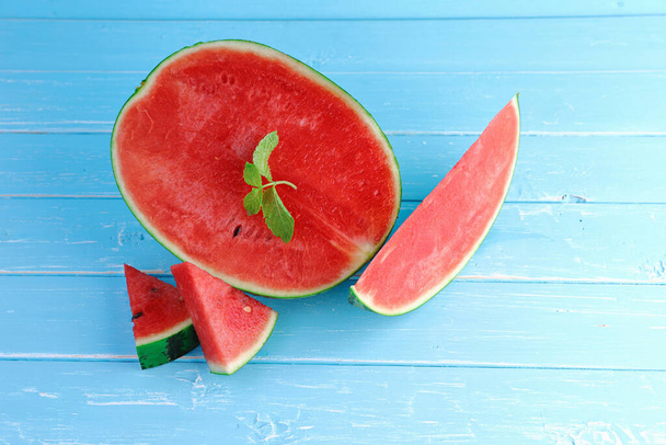 Watermelon is the fruit of summer make smoothie juice for healthy. Top view, flat lay composition slices of watermelon with mint on blue color wooden background with copy space. Summer concept. - Photo, Image