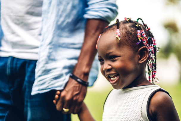 Portrait de jouir heureux amour noir famille afro-américaine père tenant petite fille africaine main dans les moments de bon temps dans le parc d'été à la maison - Photo, image