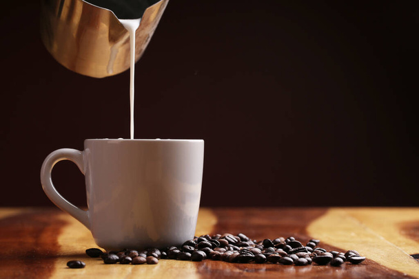 Kuuma latte, kuumaa kahvia ja maitovaahtoa puulattialla - Valokuva, kuva