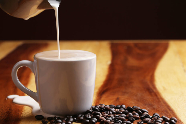 Hot latte , hot coffee and milk foam on wood floor - 写真・画像