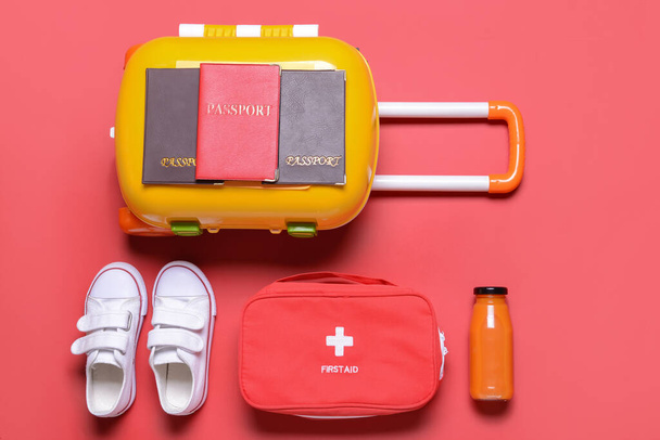 Suitcase with travel accessories for children on color background - Fotó, kép