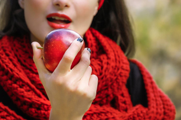 Молодая женщина ест спелое красное яблоко. Запретный плод. - Фото, изображение