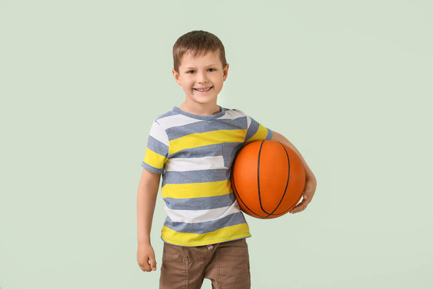 Cute little boy with ball on color background - Photo, Image
