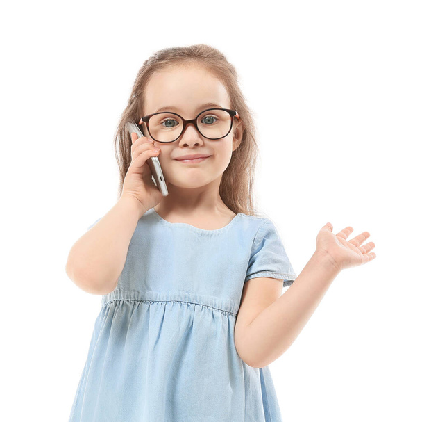 Cute little girl talking by phone on white background - Фото, изображение