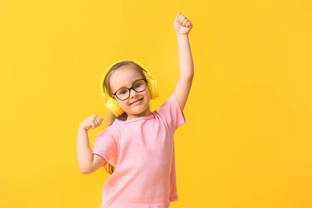 Nettes kleines Mädchen hört Musik auf farbigem Hintergrund - Foto, Bild