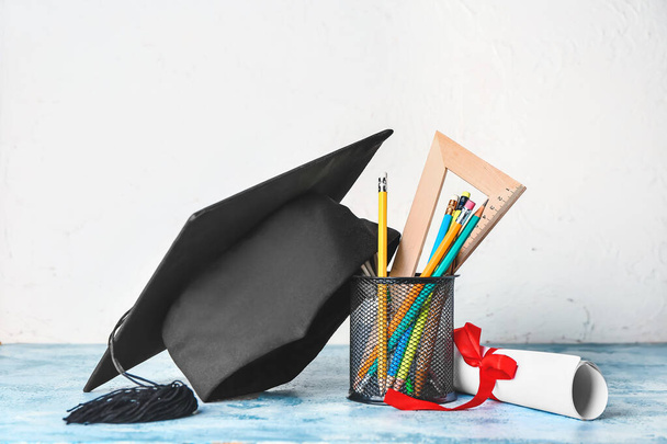 Sombrero de graduación, papelería y diploma en la mesa - Foto, Imagen