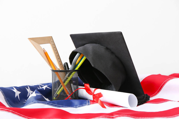 Graduation hat, stationery, USA flag and diploma on white background - Photo, Image
