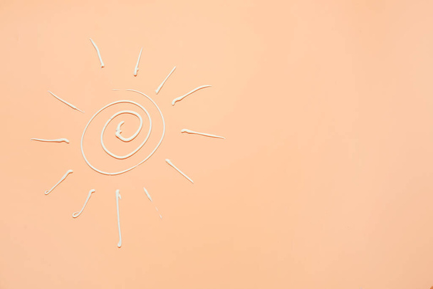 Sun drawn with sunscreen cream on color background - Photo, Image