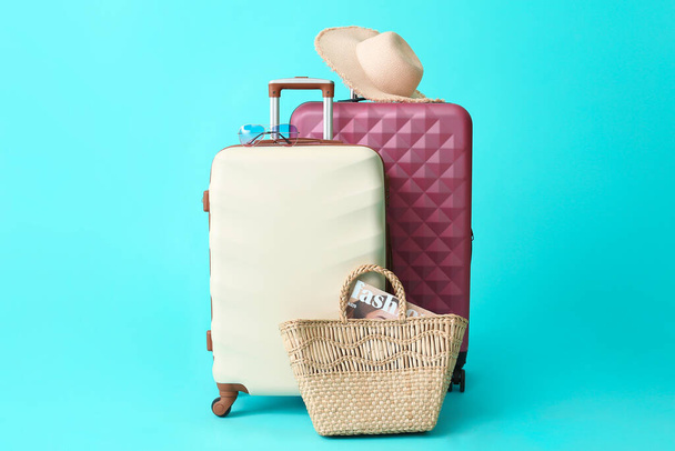 Packed suitcases with beach accessories on color background. Travel concept - Photo, Image