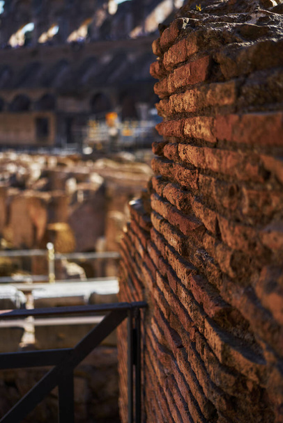 Brick wall in ruins at the arena of the Colosseum in Rome during the day - Fotó, kép