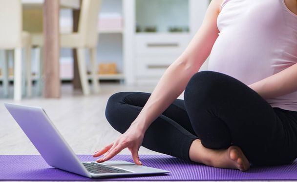 Mujer embarazada que hace ejercicio en previsión del parto - Foto, imagen