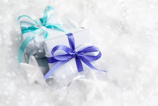 Christmas white gift boxes in snow. Winter xmas holiday theme. Merry Christmas and Happy Holidays greeting card. - Photo, Image