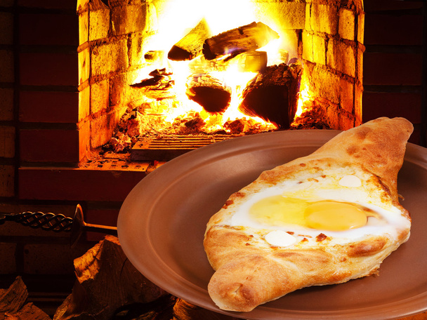 hachapuri s vejcem na desku a oheň v kamnech - Fotografie, Obrázek