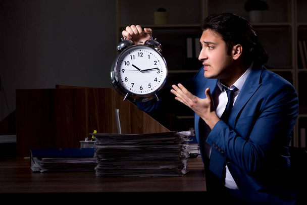 Młody mężczyzna pracownik pracujący w nocy w biurze - Zdjęcie, obraz