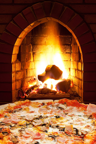Pizza au jambon, champignons et feu ouvert dans le poêle
 - Photo, image