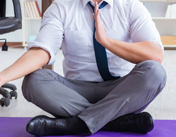 Man meditating in the office to cope with stress - Foto, immagini