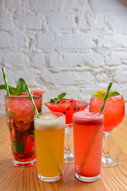 Summer cocktails and soft drinks with pieces of fruit on wooden table. Refreshing summer beverage for hot weather. Delicious cold drink with mint. Copy space banner. - Фото, зображення